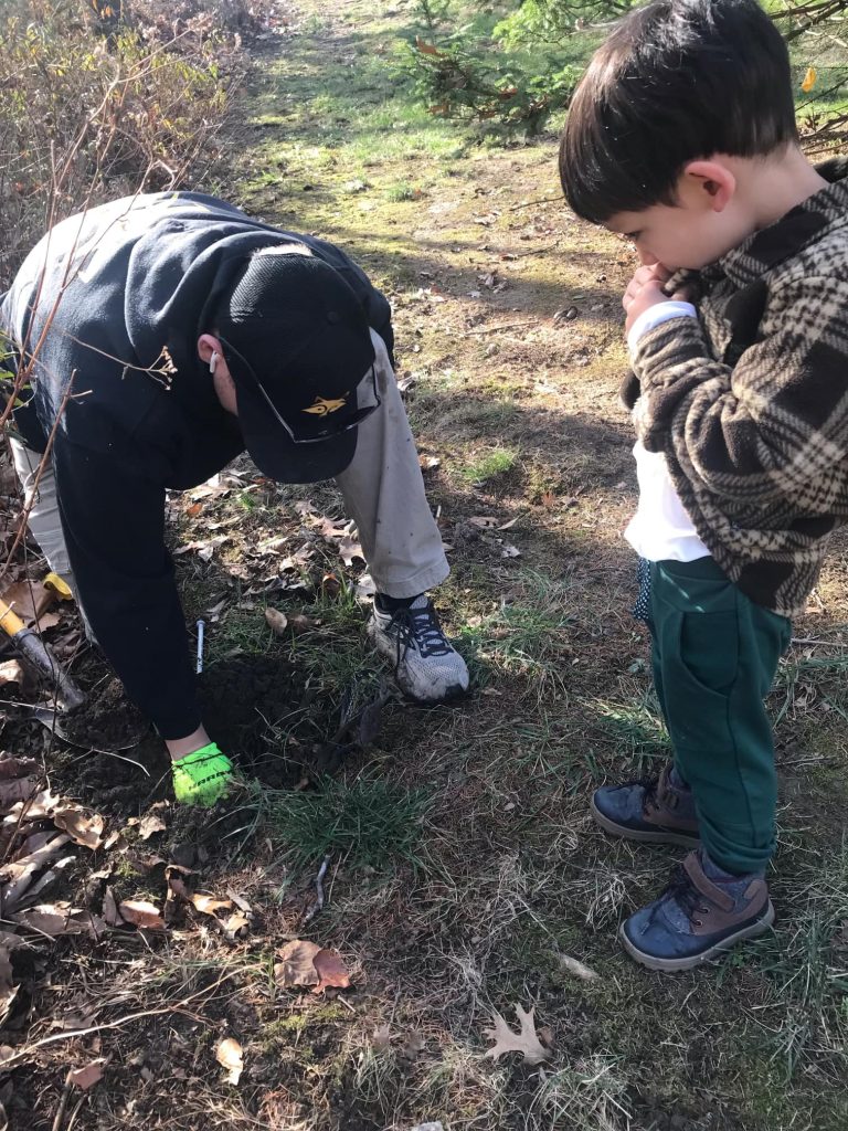 a child watches a critter control technician evict a mole